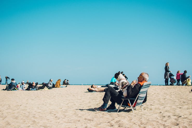 Man sitting in a beach chair with a dog