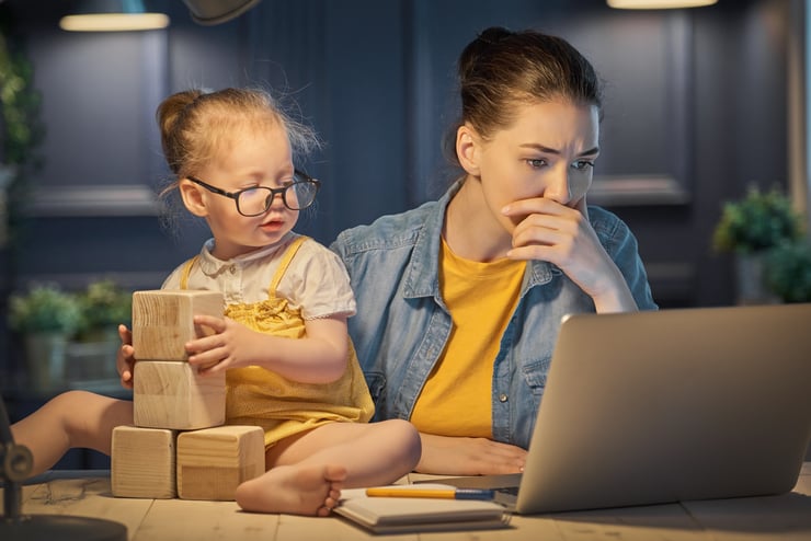 Women working at home with toddler playing blocks
